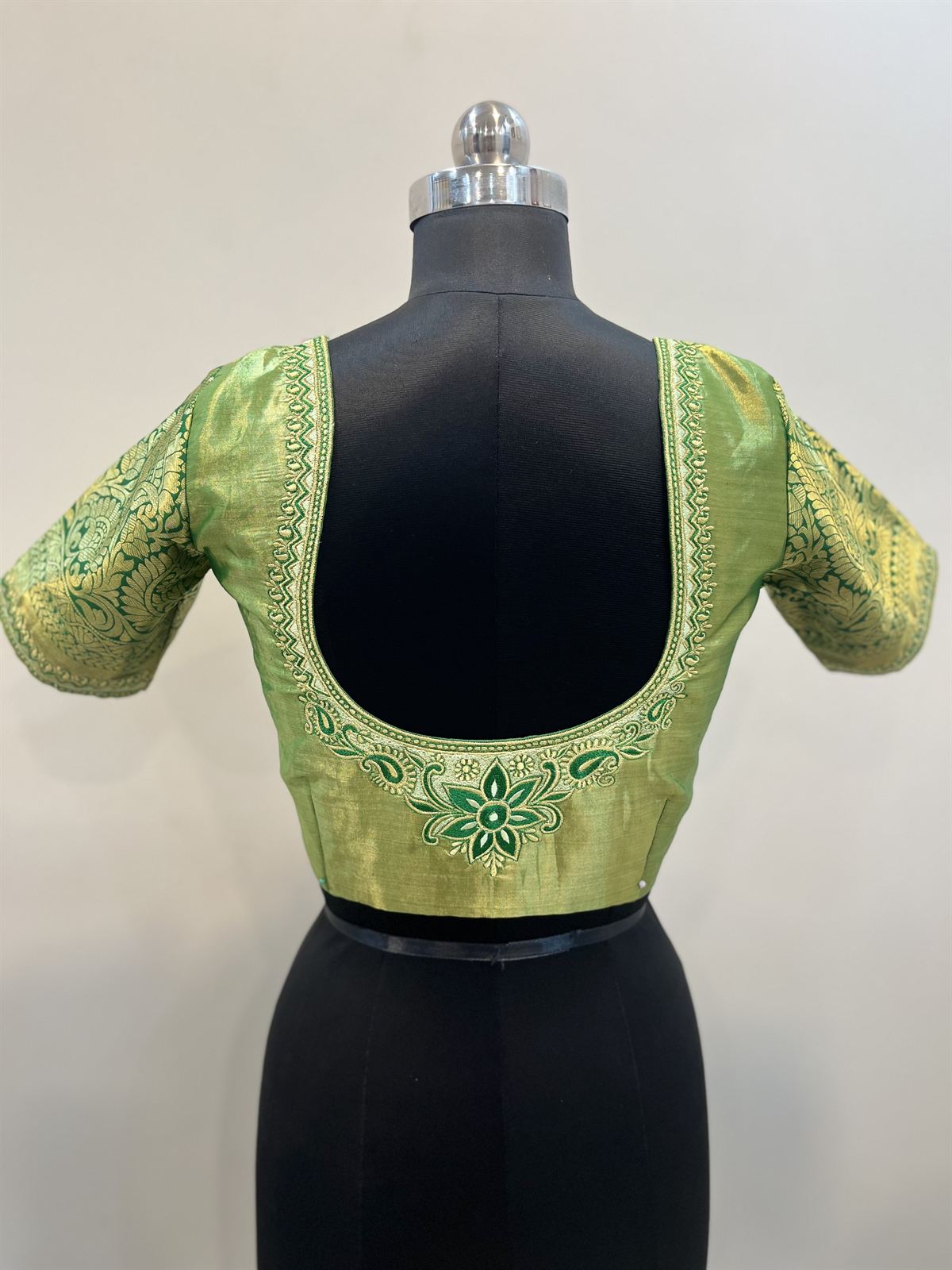 Parrot green tissue silk blouse with a deep round back and zari border